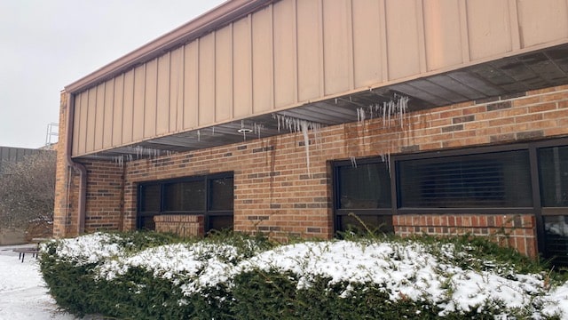 water damage professionals examine ice damming on the exterior of a commercial property leading to water damage